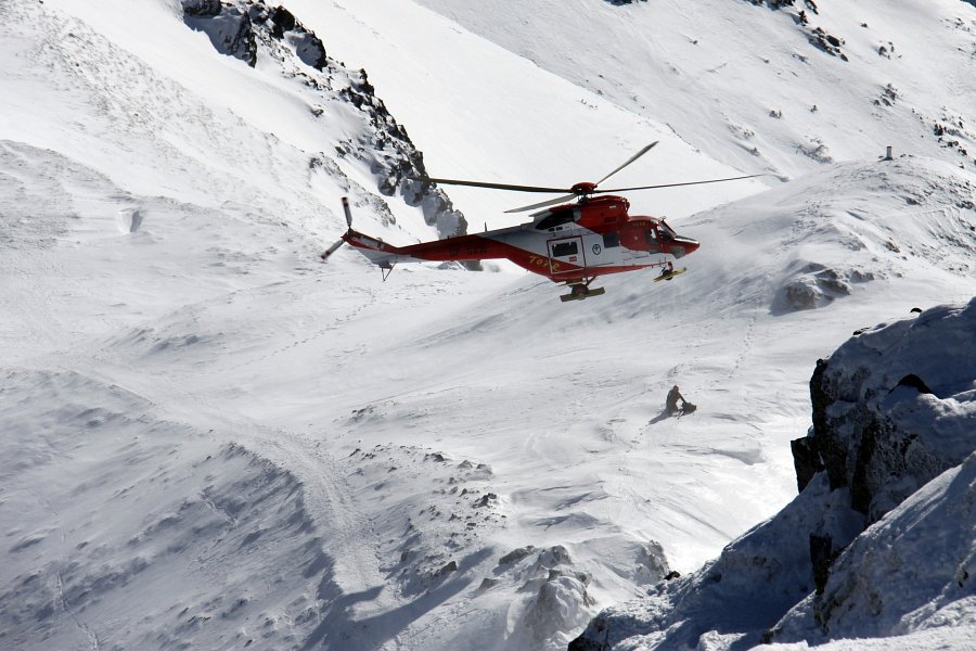 Helikopter i ratownicy w górach zimą
